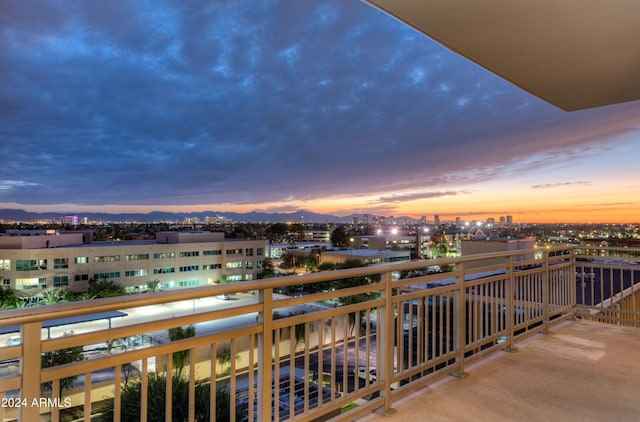 balcony at dusk featuring a mountain view