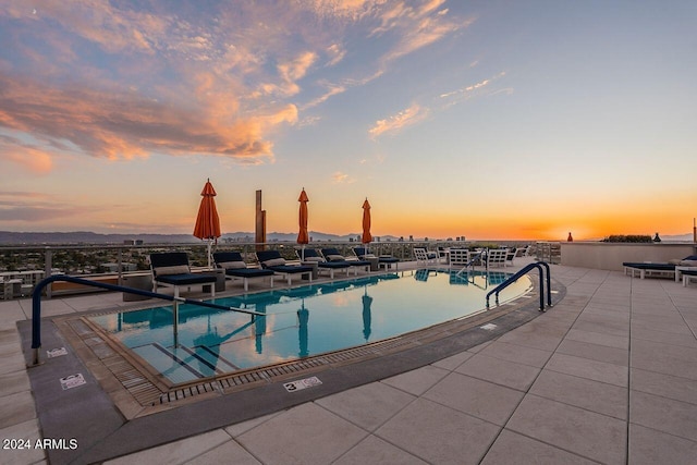 pool at dusk with a patio area