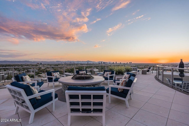 patio terrace at dusk featuring an outdoor living space with a fire pit