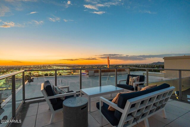 patio terrace at dusk with outdoor lounge area and a balcony