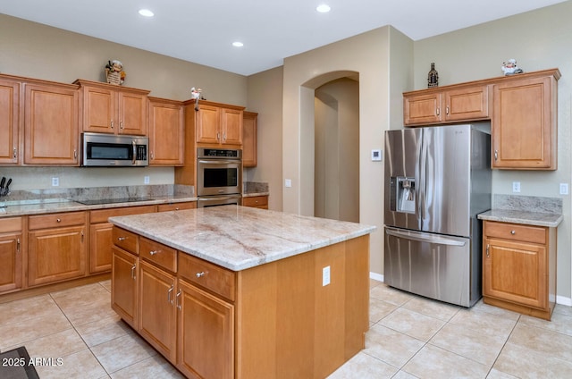 6133 W Fetlock Ter, Phoenix, AZ 85083 - kitchen featuring stainless steel appliances, arched walkways, light tile patterned flooring, a kitchen island, and recessed lighting