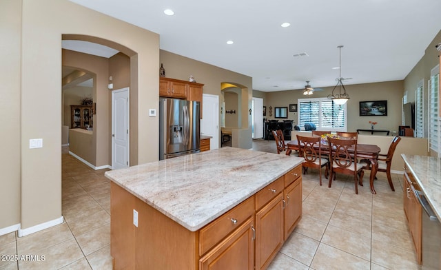 6133 W Fetlock Ter, Phoenix, AZ 85083 - kitchen featuring stainless steel appliances, arched walkways, ceiling fan, light tile patterned floors, and light stone countertops