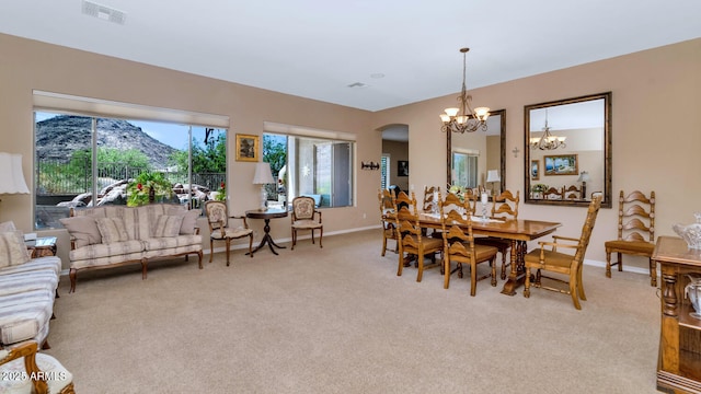 6133 W Fetlock Ter, Phoenix, AZ 85083 - dining room featuring a chandelier, arched walkways, light colored carpet, and baseboards