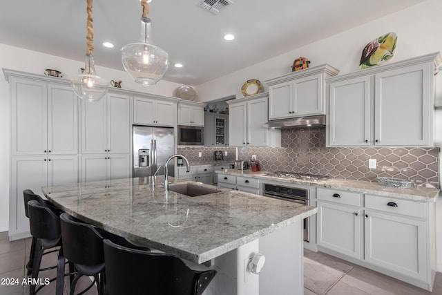 17756 E Silver Sage Ln, Rio Verde, AZ 85263 - kitchen with stainless steel appliances, a sink, under cabinet range hood, backsplash, and light tile patterned floors