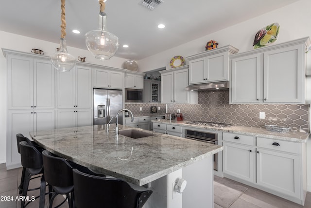 kitchen with a large island, stainless steel appliances, sink, and pendant lighting