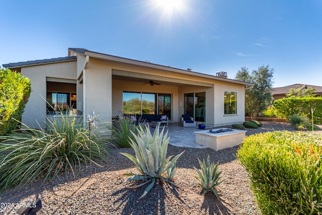 back of property with an outdoor fire pit, a patio, and ceiling fan