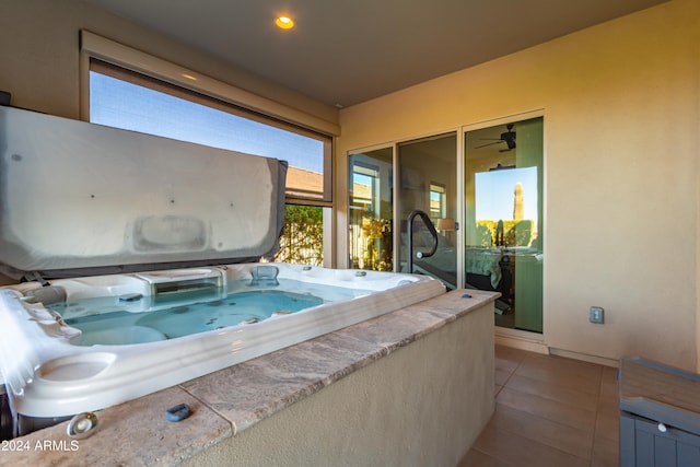 exterior space with ceiling fan, light tile patterned floors, and a jacuzzi