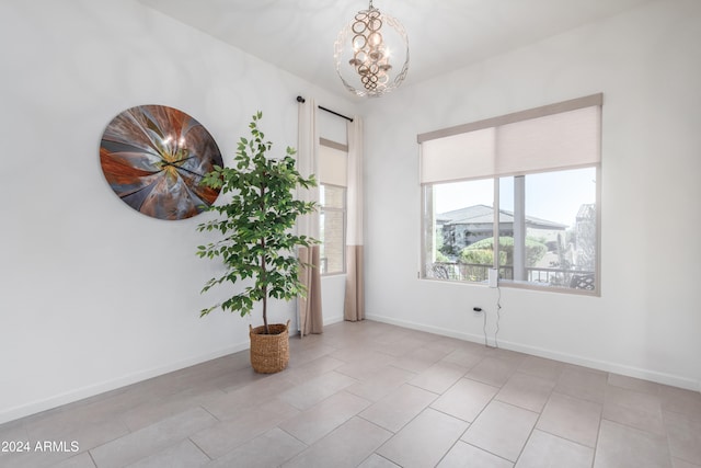 empty room featuring light tile patterned flooring and a chandelier