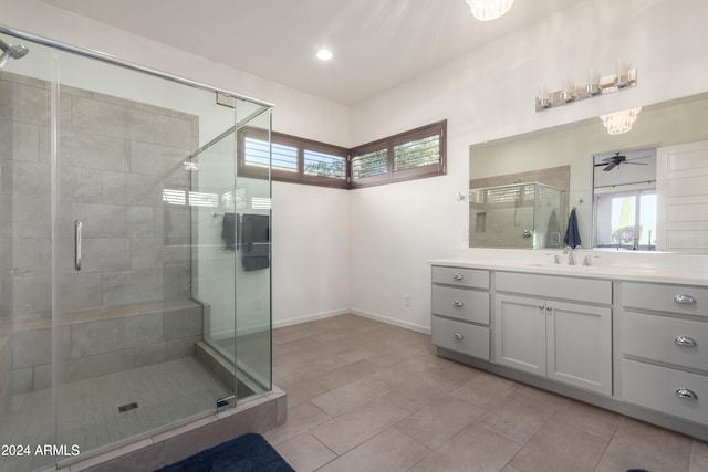 bathroom featuring a shower with door, vanity, tile patterned flooring, and ceiling fan