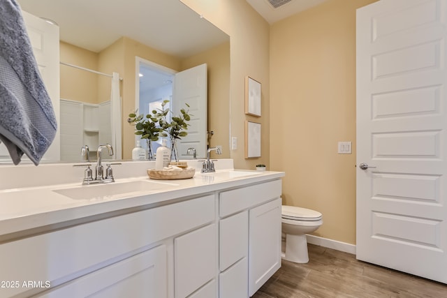 full bathroom with wood finished floors, a sink, a shower, and toilet