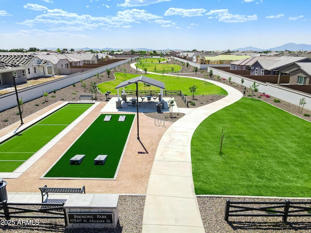view of property's community featuring fence, a yard, a residential view, a gazebo, and a mountain view