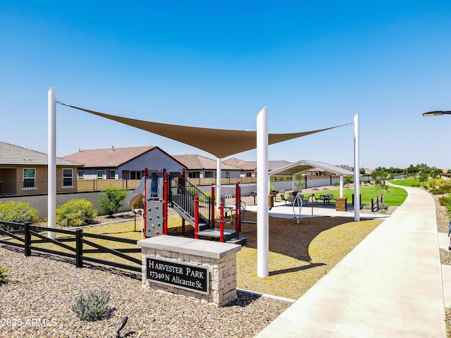 community play area featuring fence, a yard, and a residential view