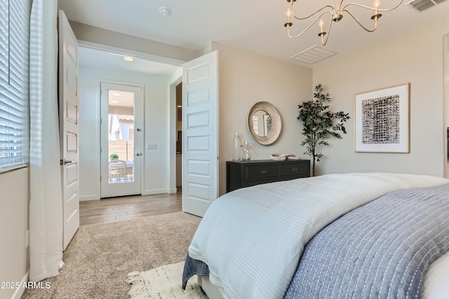 bedroom with visible vents, carpet floors, and a chandelier