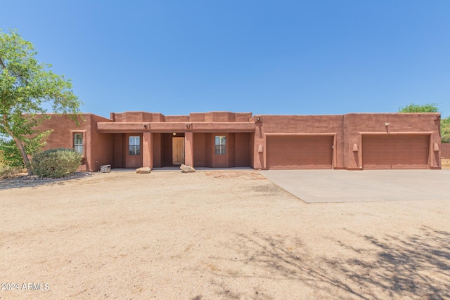 pueblo-style home featuring a garage