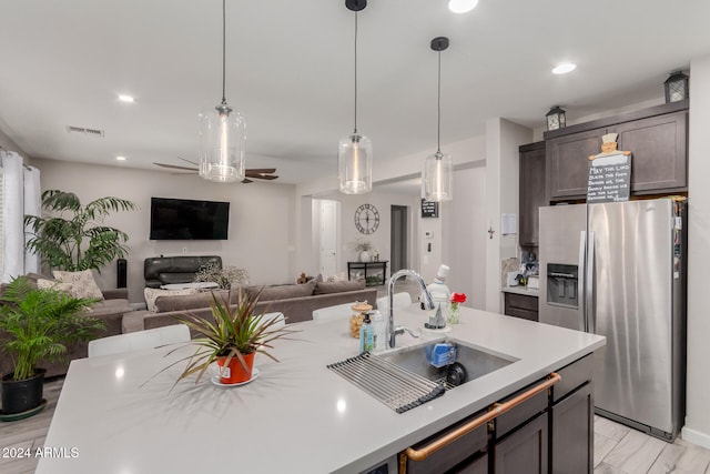 kitchen featuring pendant lighting, sink, light hardwood / wood-style flooring, ceiling fan, and stainless steel fridge