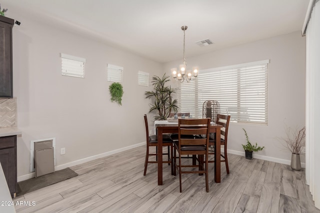 dining room with a chandelier and light hardwood / wood-style floors