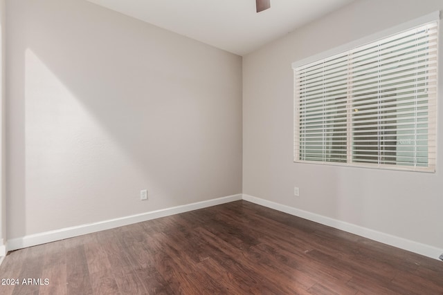 unfurnished room featuring ceiling fan and dark wood-type flooring