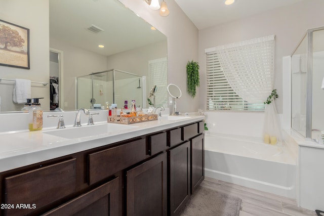 bathroom with plus walk in shower, hardwood / wood-style floors, and vanity