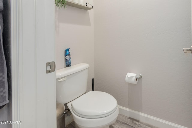 bathroom with hardwood / wood-style flooring and toilet