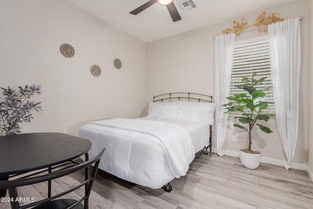 bedroom featuring ceiling fan, light hardwood / wood-style flooring, and vaulted ceiling