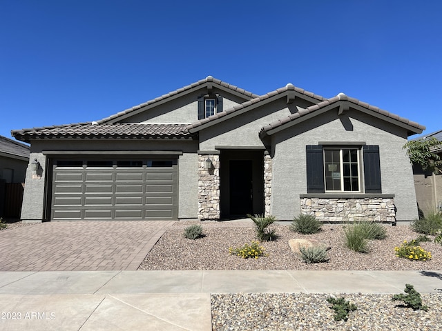 15922 W Electra Ln, Surprise, AZ 85379 - ranch-style house with stucco siding, stone siding, decorative driveway, a tiled roof, and an attached garage