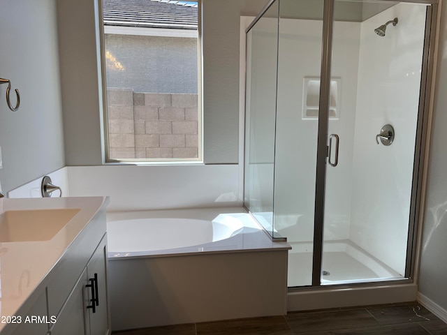 bathroom featuring plenty of natural light, shower with separate bathtub, hardwood / wood-style flooring, and vanity