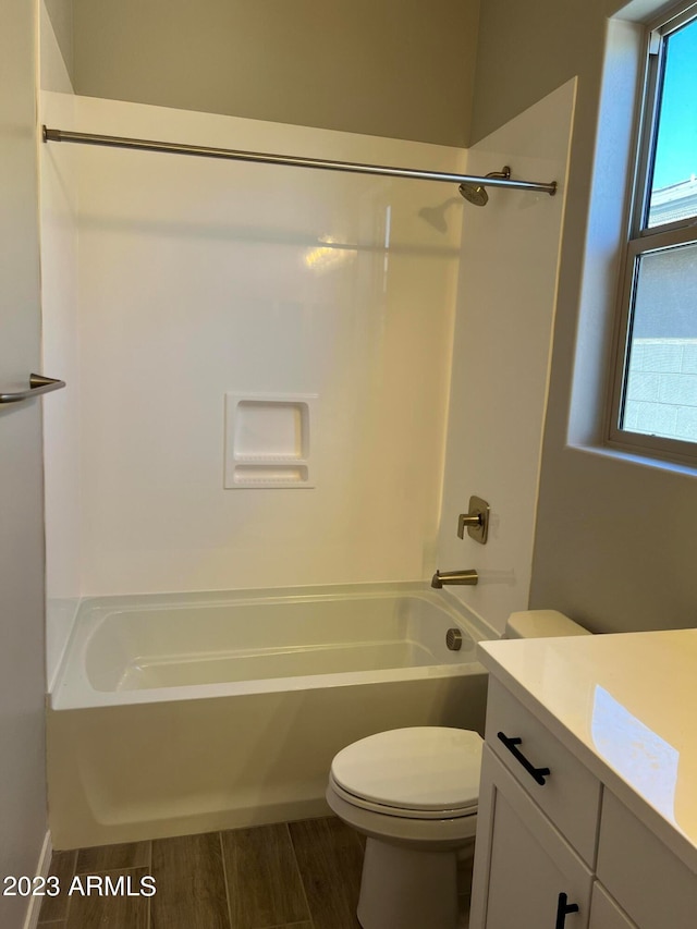 full bathroom featuring hardwood / wood-style floors, tub / shower combination, vanity, and toilet