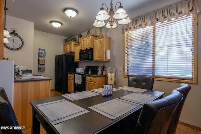 dining area with a notable chandelier, light hardwood / wood-style flooring, and sink