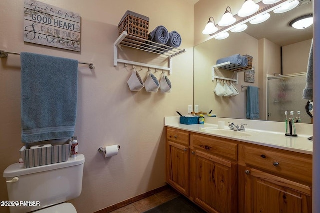 bathroom featuring vanity, toilet, an enclosed shower, and tile patterned flooring