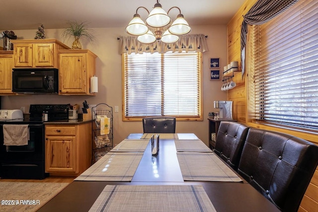 kitchen featuring pendant lighting, a notable chandelier, and black appliances