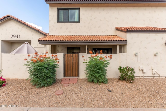 2941 N Oregon St Unit 12, Chandler, AZ 85225 - mediterranean / spanish-style home featuring a fenced front yard, a gate, a tile roof, and stucco siding