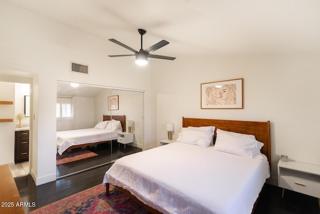 bedroom with visible vents, ceiling fan, lofted ceiling, wood finished floors, and a closet