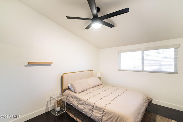 bedroom with ceiling fan, baseboards, lofted ceiling, and wood finished floors