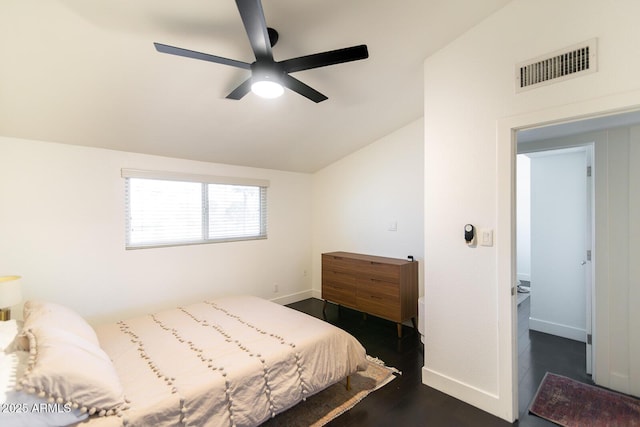 bedroom with visible vents, dark wood-style floors, baseboards, lofted ceiling, and ceiling fan