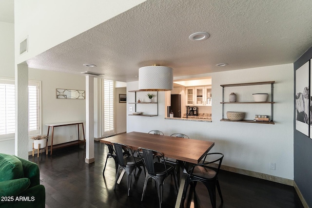 dining area featuring dark wood-style floors, visible vents, and baseboards