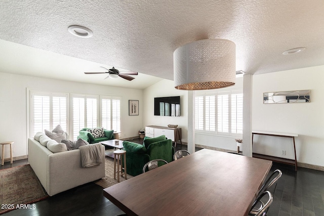 living area featuring baseboards, lofted ceiling, a healthy amount of sunlight, and wood finished floors