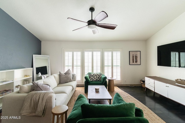 living area with vaulted ceiling, dark wood-style floors, a ceiling fan, and baseboards