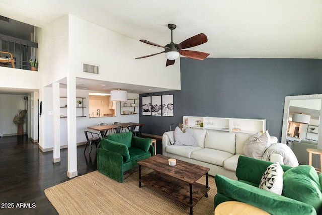 living area featuring visible vents, baseboards, wood finished floors, high vaulted ceiling, and a ceiling fan