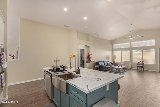 kitchen featuring an island with sink, dark wood-type flooring, and vaulted ceiling