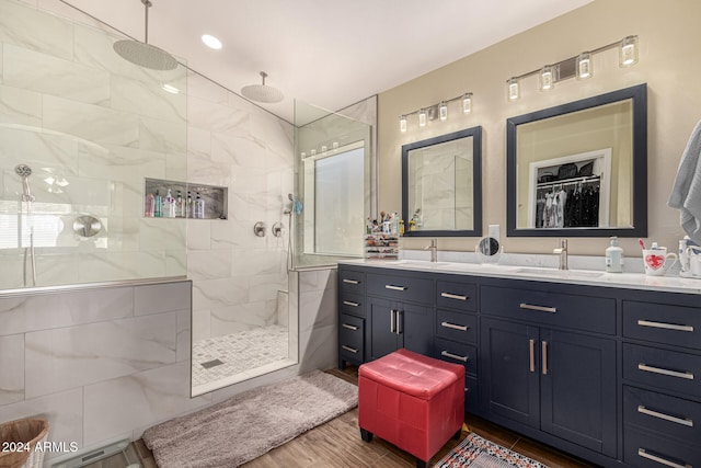 bathroom featuring vanity, wood-type flooring, and tiled shower