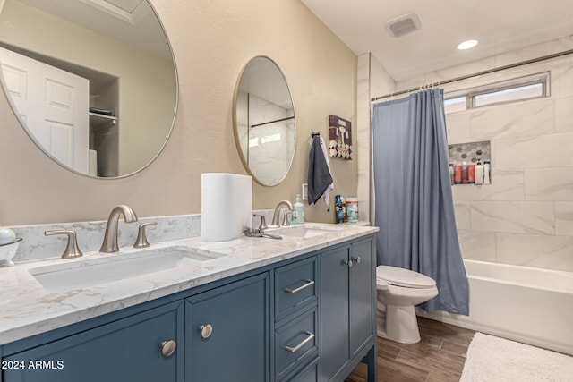 full bathroom featuring vanity, hardwood / wood-style floors, shower / tub combo with curtain, and toilet