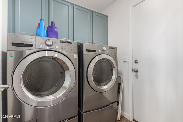 clothes washing area featuring cabinets and independent washer and dryer