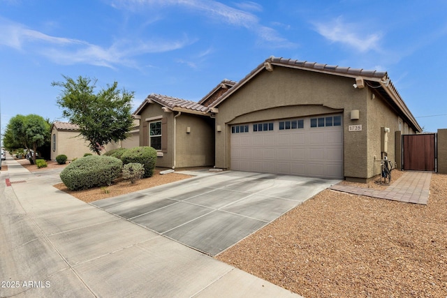 1725 E Chanute Pass, Phoenix, AZ 85040 - view of front of house with a garage, stucco siding, concrete driveway, a gate, and a tiled roof