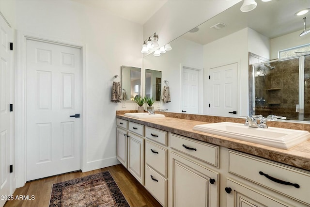 27203 N 78th Ln, Peoria, AZ 85383 - full bathroom featuring a shower stall, wood finished floors, double vanity, and a sink