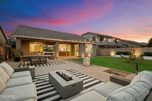 27203 N 78th Ln, Peoria, AZ 85383 - back of property at dusk featuring a tiled roof, an outdoor living space with a fire pit, fence, a patio, and outdoor dining area