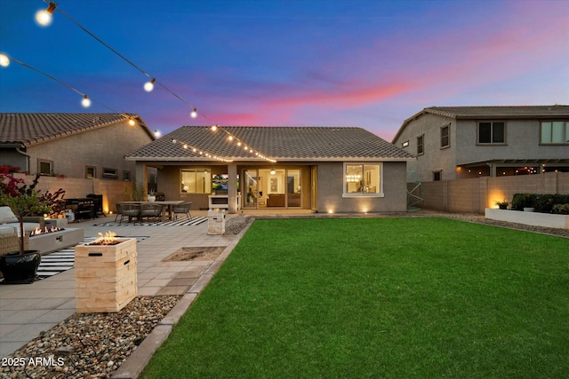 27203 N 78th Ln, Peoria, AZ 85383 - back of property with a patio, stucco siding, a fenced backyard, an outdoor fire pit, and a yard