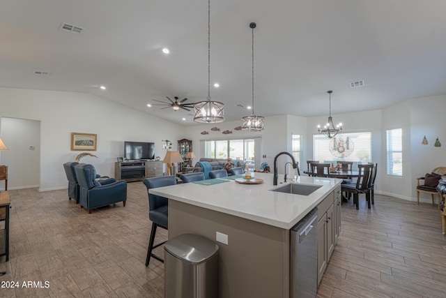 kitchen with ceiling fan with notable chandelier, light hardwood / wood-style floors, sink, and a center island with sink