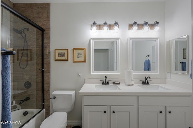 full bathroom with toilet, bath / shower combo with glass door, and vanity