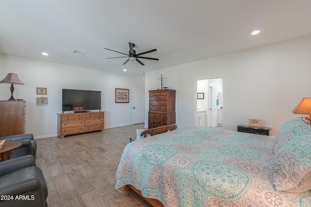 bedroom featuring ensuite bath, wood-type flooring, and ceiling fan