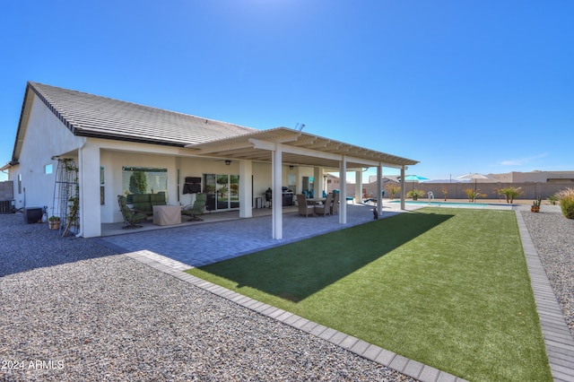 rear view of house with a patio area, a lawn, and an outdoor living space